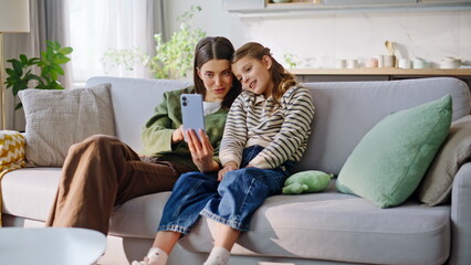 Obraz premium Child babysitter browsing cellphone social media sitting together apartment