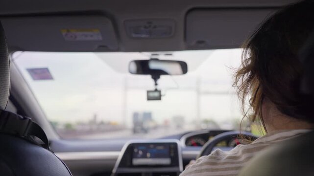 A female driver commuting in her car with a dashcam recording, offering an authentic passenger point of view of urban transportation and daily mobility.