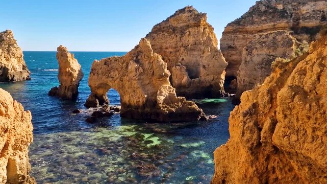 Portugal Algarve 4k video top view of Praia da Marinha yellow cliffs with boats sailing through rock arches. Scenic Atlantic ocean coast and turquoise water in Lagoa. Summer travel destination