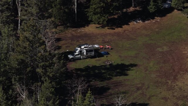 Aerial of RV camped in meadow with dirt bikes in Cloudcroft New Mexico Lincoln National Forest in spring