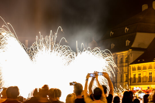 Long exposure motion blurred photograph. SIBIU, ROMANIA: People are watching a firework display in a city square