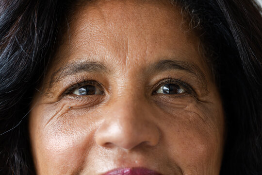 Middle-aged African American woman facing camera in studio, wearing dark lipstick and eye makeup