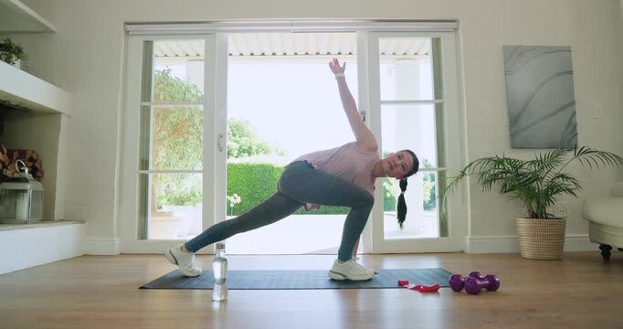 African woman pink top on mat at home kneeling lunging twisting rowing dumbbell planking for core