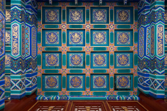 Ornate coffered ceilings painted with golden dragons and vibrant patterns decorate a traditional building at the Summer Palace in Beijing.