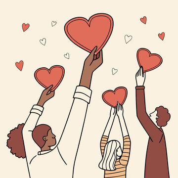 A diverse group of people joyfully raise red and white hearts above their heads representing love unity and positive emotions high quality