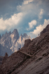 Fototapeta premium Hiker walking mountain trail in dolomites landscape
