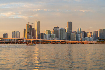 Fototapeta premium Miami skyline at golden hour with MacArthur Causeway and sunlight reflections on Biscayne Bay