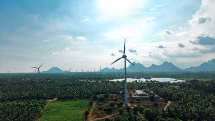 Wind turbines by lake with mountain backdrop and bright sky landscape © VisualTreat12