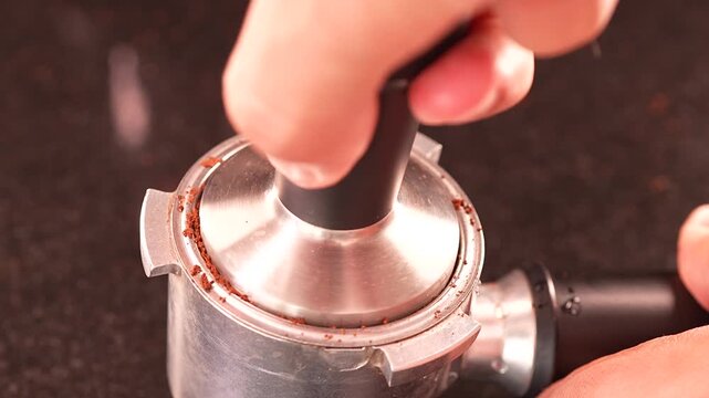 Kaffepulver wird mit dem Tamper in den Portafilter gepresst
