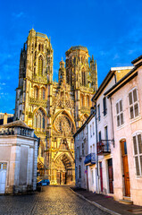 Scenic view of the ornate gothic facade and towers of Saint Stephen Cathedral along a cobblestone street in Toul, Meurthe-et-Moselle, France