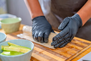 Chef hands preparing sushi maki roll © Guillermo Spelucin