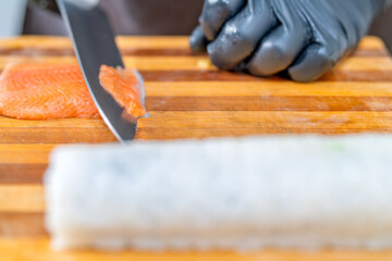 Chef slicing fresh salmon for nikkei maki © Guillermo Spelucin