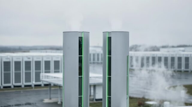 Medium shot focused on energyefficient vapor towers of an ecofriendly ISP facility emphasizing green technology with softfocus battery units behind.