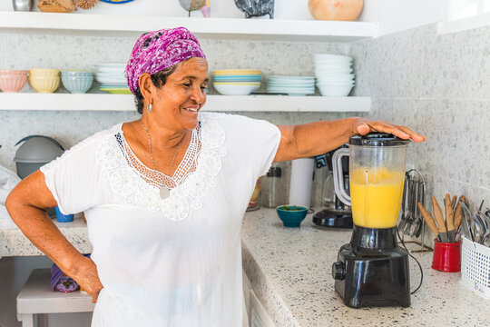 Woman blends tropical juice in a Caribbean kitchen