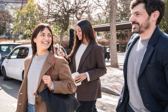 Business colleagues walking to office and chatting outdoors