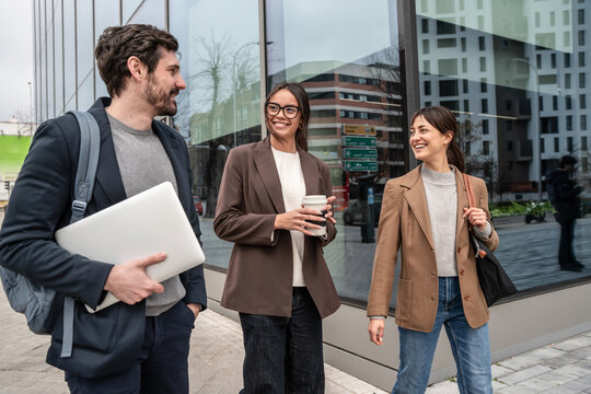 Business colleagues chatting outside modern office building