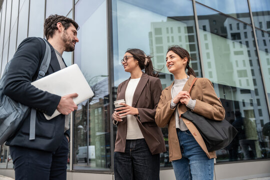 Business colleagues networking outside modern office building