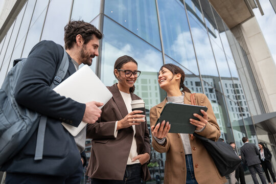 Business colleagues collaborating outside modern office building