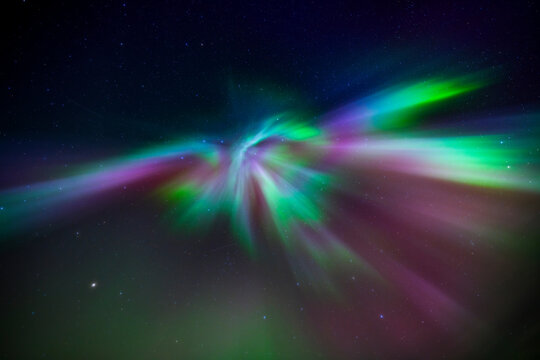 Northern lights swirling over Finnish night sky with stars