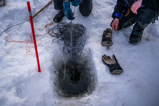 Winter ice fishing with net at lake hole in Finland