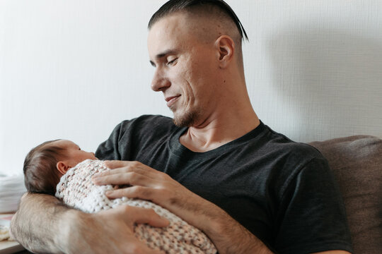 Father lovingly cradling his newborn daughter