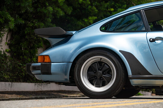 Blue Porsche 930 Turbo rear wheel and duck tail spoiler, Classic sports car exterior detail outdoors