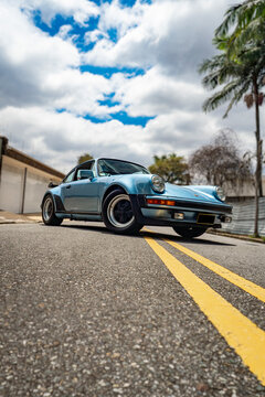 Blue Porsche 930 Turbo front low angle perspective, Classic sports car on asphalt road