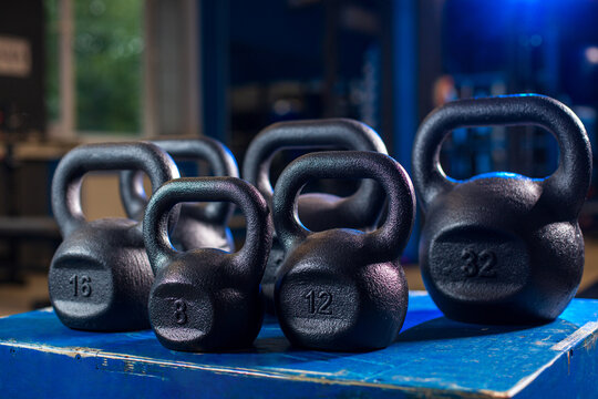 Kettlebells set on gym platform with window light, fitness and strength training concept