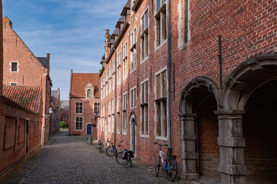 Historic brick houses and cobblestone street in Groot Begijnhof - Leuven, Belgium