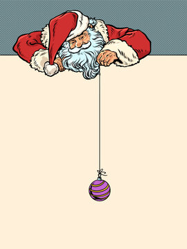 Pop Art Retro Santa Claus holding a Christmas tree bauble on a string. Celebrate the approach of Christmas and New Year with Santa Claus. Find discounts on New Year's holidays and gifts.