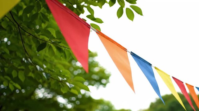 Colorful triangular pennant flags hanging from a tree branch