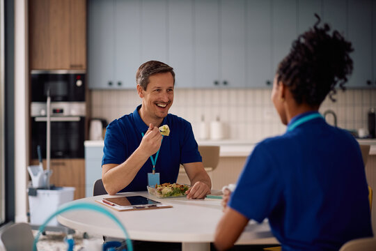 Happy professional cleaner and his female coworker enjoying in lunch break.