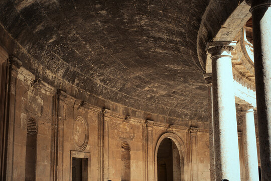 Charles v palace courtyard interior in alhambra, showing renaissance architecture, ancient stone columns, and domed ceiling