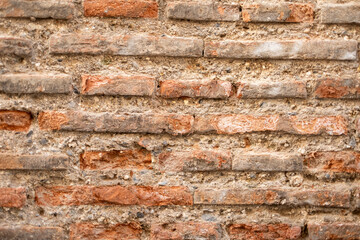Naklejka premium Old brick wall texture with red bricks and weathered mortar, showing history, age, and decaying architecture