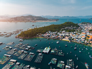 Aerial view Floating fish farms and boats off coastal village in bay © Parilov