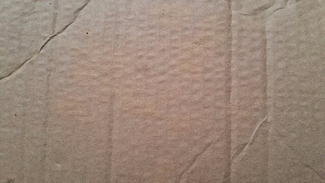 A close-up view of a worn and creased cardboard surface