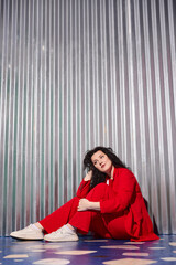 Obraz premium Chic woman in red exudes confident relaxed aura outdoors