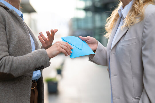 Businesswoman giving important document in blue envelope