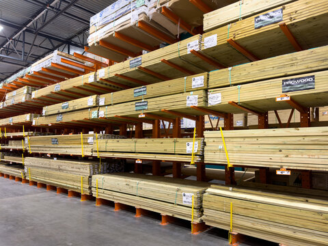 Prosper, Texas, USA - April 1st, 2026: Prowood pressure treated pine lumber boards organized on orange metal cantilever racks inside The Home Depot