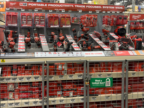 Prosper, Texas, USA - April 1st, 2026: Large display of red Milwaukee M12 portable productivity cordless tools organized behind grey metal security cage in The Home Depot