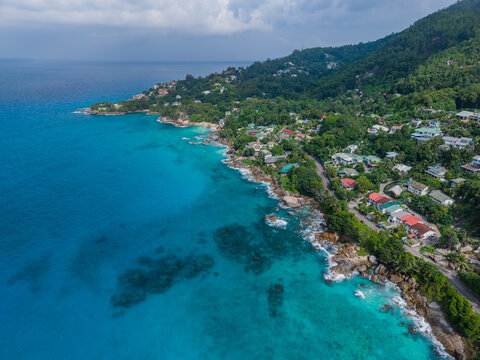 Aerial view of turquoise waters meeting the lush green coastlines near Vista do Mar, creating a vibrant contrast of nature's beauty, Vista do Mar, Mahe Island, Seychelles.