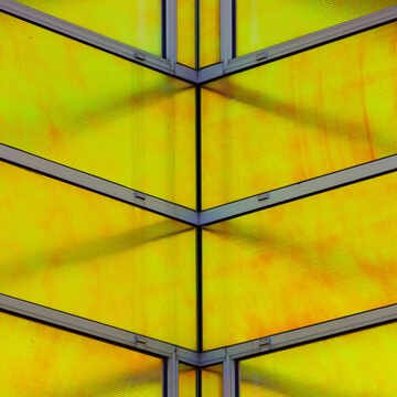 View of geometric architecture with vibrant yellow panels intersected by stark gray frames, creating a dynamic contrast of color and form, La Defense, Flevoland, Netherlands.