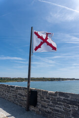 Fototapeta premium Cross of Burgundy, Spanish colonial military flag flying over Fort Matanzas National Monument in St. Augustine, Florida. Spanish fort to guard Matanzas Inlet in conjunction with Castillo de San Marcos