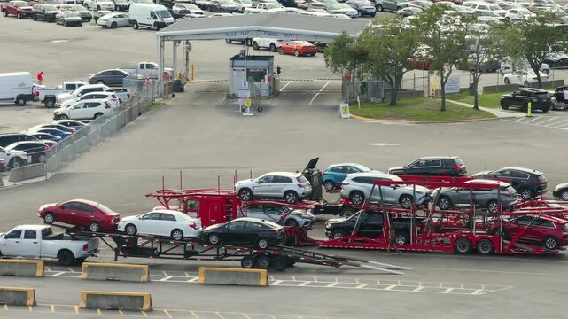 Used cars on car hauler semi truck tractors at dealer auction reseller company big parking lot ready for resale services. Sales of secondhand vehicles.