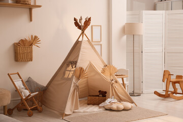 Stylish wigwam with dry leaves in child's room © New Africa