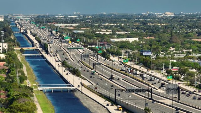 View from above of USA transportation infrastructure. Top view of multilane American highway with rapid driving cars during rush hour in Miami, Florida.