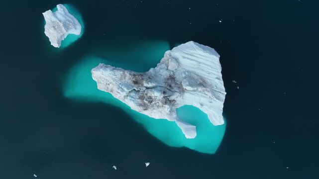 Drone shot of icebergs floating in a large fjord of East Greenland