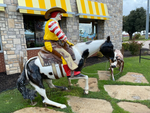 Weatherford, Texas: A western-theme McDonald's features an outdoor statue of Ronald McDonald lassoing a calf. Cowboy Ronald McDonald with cowboy hat riding a horse.