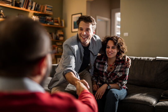 Smiling couple greeting advisor in living room