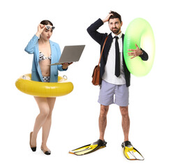Office workers dreaming about vacation. Man and woman with inflatable rings, laptop and swim flippers on white background © New Africa